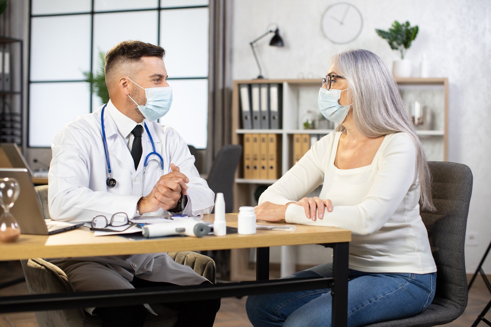 Aged woman in mask having check up at modern clinic